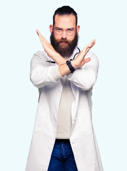 医療コートを着た若いブロンドの医者の男は 否定的なサインをする腕を横切る表情を拒絶し 怒った顔 — ストック写真