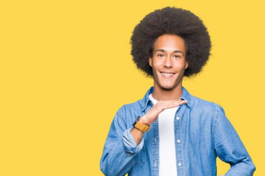 Afro saç ile genç Afrikalı Amerikalı adam büyük ve büyük boy işareti gösteren eller ile işaret, ölçü sembolü. Kameraya bakarak gülümsüyor. Ölçme konsepti.