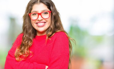 Kırmızı gözlük mutlu yüz ile gülümseyen giyen genç güzel kadın silah kameraya bakarak geçti. Olumlu bir kişi.