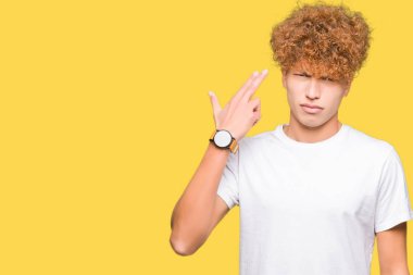 Genç yakışıklı adam ile afro saç giyen Casual beyaz t-shirt ateş ve kendini gösteren el ve parmaklar baş, intihar jest işaret.