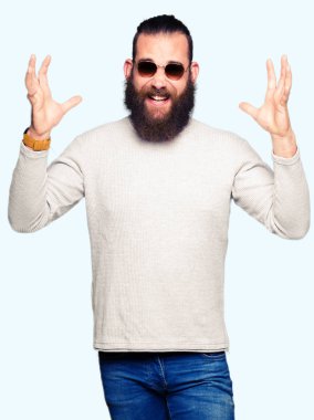 Genç hipster adam kızgın ve silah ile başarı için deli kutluyor güneş gözlüğü takıyor kaldırdı ve heyecanlı çığlık gözler kapalı. Kazanan kavramı