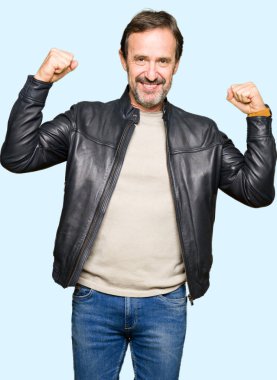 Siyah deri ceket gösteren kol kasları gururlu gülümseyen giyen orta yaş yakışıklı adam. Fitness kavramı.