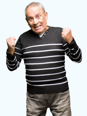 Kış kutlama çizgili süveter giymiş yakışıklı komuta sizde şaşırttı ve başarı için kaldırdı kollarını açarak hayret ve gözleri açık. Kazanan kavramı.