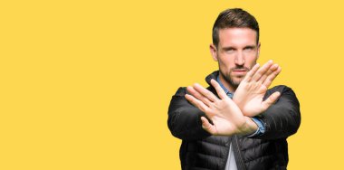 Yakışıklı adam giyen kış bayrak ret ifade geçiş ve avuç içi eksi işareti, kızgın surat yapıyor