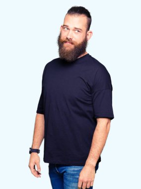 Rahat tişört giyen genç sarışın adam görünümlü bakan yan ve uzak düşünme bakıyor.