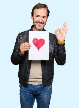 Parmak ile ok işareti yapıyor kırmızı kalp ile kağıt tutan yakışıklı Orta Çağ adam, mükemmel sembolü