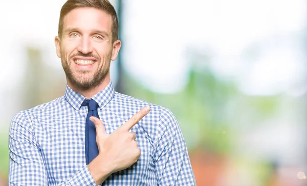 Handsome business man wearing tie cheerful with a smile of face pointing with hand and finger up to the side with happy and natural expression on face