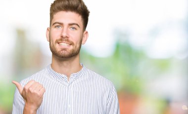 Yakışıklı delikanlı arıyor ve başparmak yanında yukarıyı mutlu yüz ile gülümseyen.