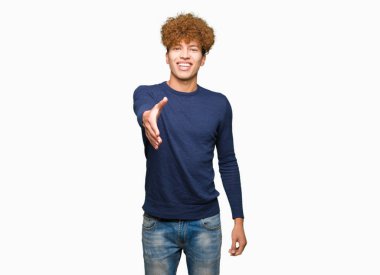 Afro saç ile genç yakışıklı adam tebrik ve davetkar olarak dostu sunan el sıkışması gülümseyen. Başarılı iş.