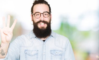 Uzun saç ve sakal gösterilen ve parmakları ile işaret gözlüklü genç hipster adamla dört kendinden emin ve mutlu gülümseyerek iken numara.