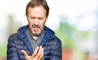 Orta yaş yakışıklı adam kış ceket giyen ellerde ve parmaklarda ağrı acı, artrit iltihabı