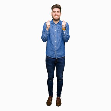 Genç yakışıklı sarışın adam rahat kot gömlek kolları olan başarı için heyecanlı zafer kutluyor gülümseyen kaldırdı. Kazanan kavramı.