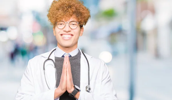 Young Handsome Doctor Man Wearing Medical Coat Praying Hands Together — Stock Photo, Image