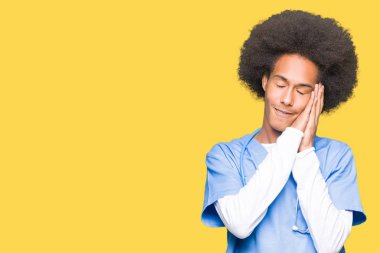 Uyku yorgun hayal ve eller ile birlikte kapalı gözlerle gülümseyerek poz afro saçlı genç Afro-Amerikan Doktor adam.