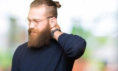 Gözlük ve balıkçı yaka kazak giyen genç sarışın adam eliyle, kas ağrısı boyun dokunmadan boyun ağrısı yaralanma acı