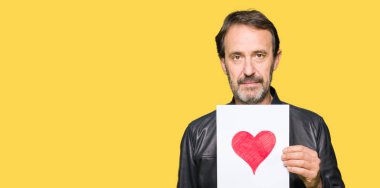 Kendinden emin bir ifade ile kırmızı kalp ile kağıt ciddi düşünme acımak yüz tutan yakışıklı orta yaş erkek