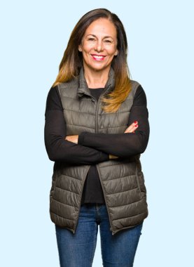 Kış yelek ile mutlu yüz gülümseyen giyen güzel orta yaş kadın silah kameraya bakarak geçti. Olumlu bir kişi.