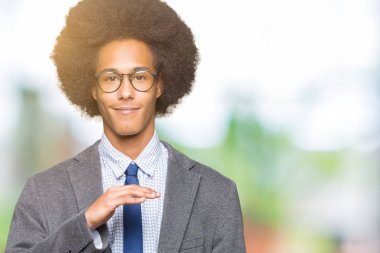 Eller eller büyük gösterilen ve büyük boy işareti, ölçü birimi sembolü ile gözlüklü afro saçlı genç Afro-Amerikalı iş adamı. Kameraya bakarak gülümsüyordu. Ölçüm kavramı.