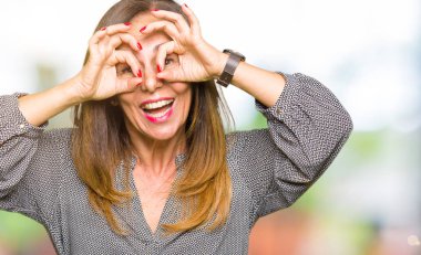 Güzel orta yaş iş kadın dürbün yapışması gibi ok jest yapıyor, gözleri parmaklarla bakıyor. Çılgın ifade.