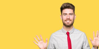 Gösterilen ve parmakları ile işaret genç yakışıklı iş adamı kendinden emin ve mutlu gülümseyerek süre on numara.