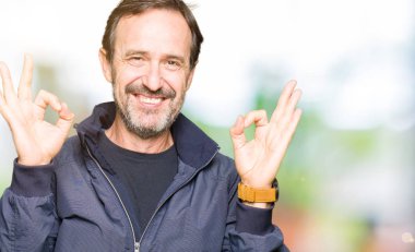 Orta yaş yakışıklı adam bir ceket giyen rahatlayın ve gözleri parmakları ile meditasyon jest yapıyor kapalı gülümseyerek. Yoga konsepti.