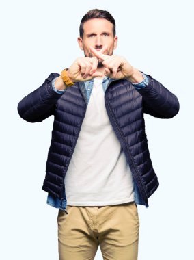 Yakışıklı adam giyen kış ceket ret ifade geçiş parmakları eksi işareti yapıyor