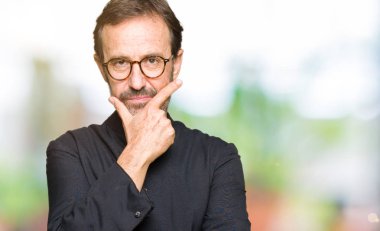 Katolik giyen orta yaş rahip adam robe emin çapraz kollar ve çeneme kaldırdı el ile gülümseme ile kameraya bakıyor. Pozitif düşünce.