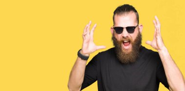 Genç hipster adam kızgın ve silah ile başarı için deli kutluyor güneş gözlüğü takıyor kaldırdı ve heyecanlı çığlık gözler kapalı. Kazanan kavramı