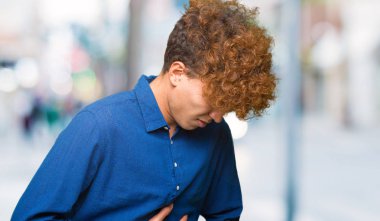 Karnında el ile afro saç ile genç yakışıklı zarif adam mide bulantısı nedeniyle, ağrılı hastalık duygusunu. Ağrı kavramı.