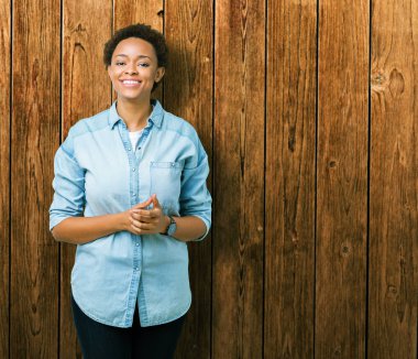 İzole arka plan el ele tutusun genç güzel Afrikalı-Amerikalı kadın ve rahat ve neşeli gülümseyen parmak çarpı işareti. Başarı ve iyimser