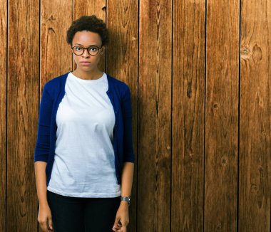 İzole arka plan şüpheci ve sinir, papatyanın üzgün üzerinde sorunu nedeniyle gözlüklü genç güzel Afrikalı-Amerikalı kadın. Negatif kişi.