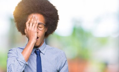 Afro saçlı gözlüklü genç Afro-Amerikalı iş adamı Yawning yarım yüz, göz ve ağız el ile kapsayan yorgun. Acı yüzü acıyor.