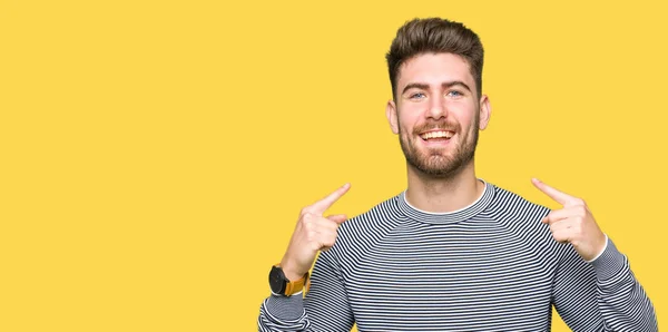 若いハンサムな男性が自信を示すと指歯と口を指して笑ってストライプ セーターを着ています 健康の概念 — ストック写真