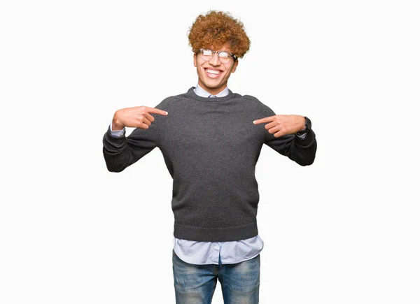アフロヘアの若いハンサムなビジネスマンは 笑顔で自信を持って見えるメガネをかけた 誇りと幸せな指で自分自身を指差す — ストック写真