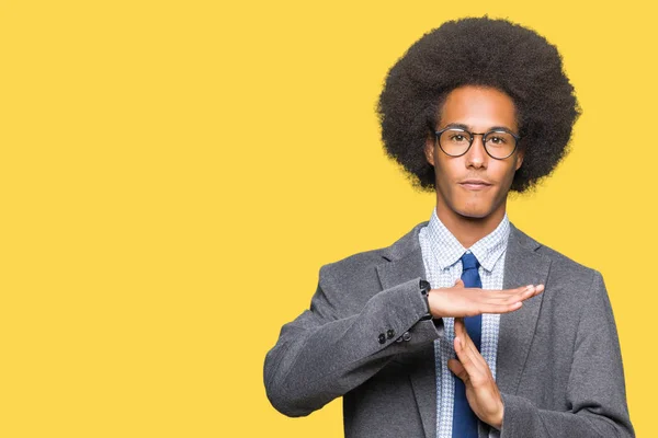 Young african american business man with afro hair wearing glasses Doing time out gesture with hands, frustrated and serious face