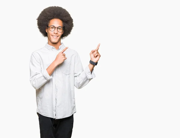 非洲青年美国男子戴着眼镜戴着眼镜微笑着看着镜头 用两只手和手指指着一边 — 图库照片