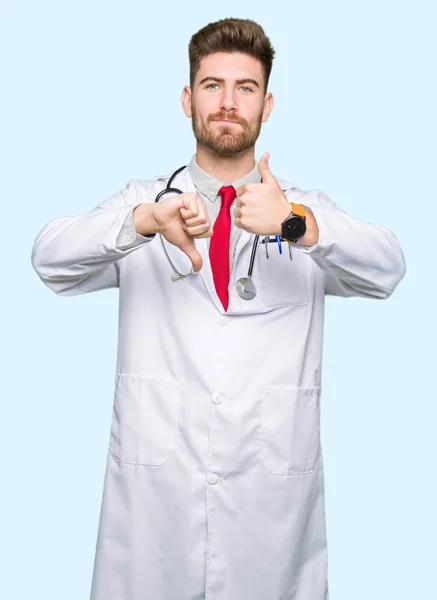 Young Handsome Doctor Man Wearing Medical Coat Doing Thumbs Disagreement — Stock Photo, Image