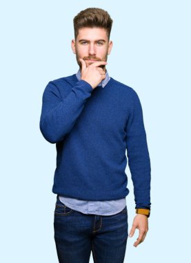 Çapraz kollar ve çeneme kaldırdı el ile gülümseme ile kamera kendinden emin görünen genç yakışıklı iş adam. Pozitif düşünce.