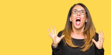 Güzel orta yaş kadın çılgın ve kızgın bağırarak ve agresif ifade ve silah kaldırdı bağırmaya gözlüklü. Hayal kırıklığı kavramı.