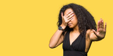 Genç güzel kız moda giyen kıvırcık saçlı kapsayan gözlerin ellerle etek ve dur jest ile acı ve korku ifadesi. Utandım ve negatif kavramı.