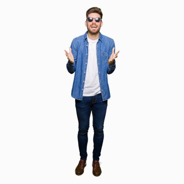 Genç yakışıklı zarif adam kot ceket giyen deli kutluyor ve kollarını kaldırdı ve açık gözleri heyecan çığlık ile başarı için hayran. Kazanan kavramı