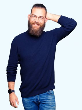 Gözlük ve balıkçı yaka kazak giyen genç sarışın adam el yukarı jest ile emin dokunmadan saç gülümsüyor, çekici poz