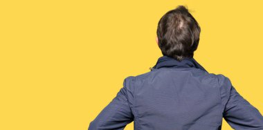 Geriye doğru uzakta silah ile vücut üzerinde seyir bekleyen bir ceket giyen orta yaş yakışıklı adam