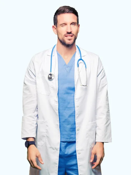 セクシーな表情 明るく 幸せな顔でカメラを見てウィンクしている孤立した背景に医療制服を着てハンサムな医者の男 — ストック写真