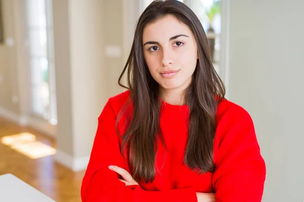 カジュアルな赤いセーターを着た美しい若い女性は懐疑的で緊張し 両腕を組んで顔に不承認の表現 負の人 — ストック写真