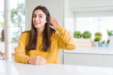 Sarı süveter giyen güzel genç bir kadın kulağına fısıldayarak dedikoduları ve dedikoduları dinliyor. Sağırlık kavramı.