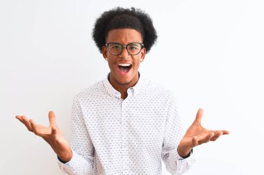 Zarif gömlek ve gözlük takan genç Afro-Amerikalı adam izole edilmiş beyaz arka planda çılgınca bağırıyor ve agresif bir ifade ve kollarla bağırıyor. Hayal kırıklığı konsepti.