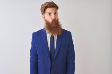İzole edilmiş beyaz arka planda takım elbiseli genç kızıl saçlı işadamı dudaklı balık suratı yapıyor, çılgınca ve komik bir jest. Komik ifade.