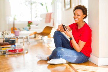 Güzel genç African Amerikan kadın oturma üzerinde the zemin istimal