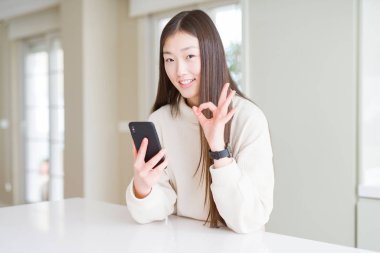 Akıllı telefon kullanan güzel Asyalı kadın parmaklarıyla imza atıyor, mükemmel bir sembol.